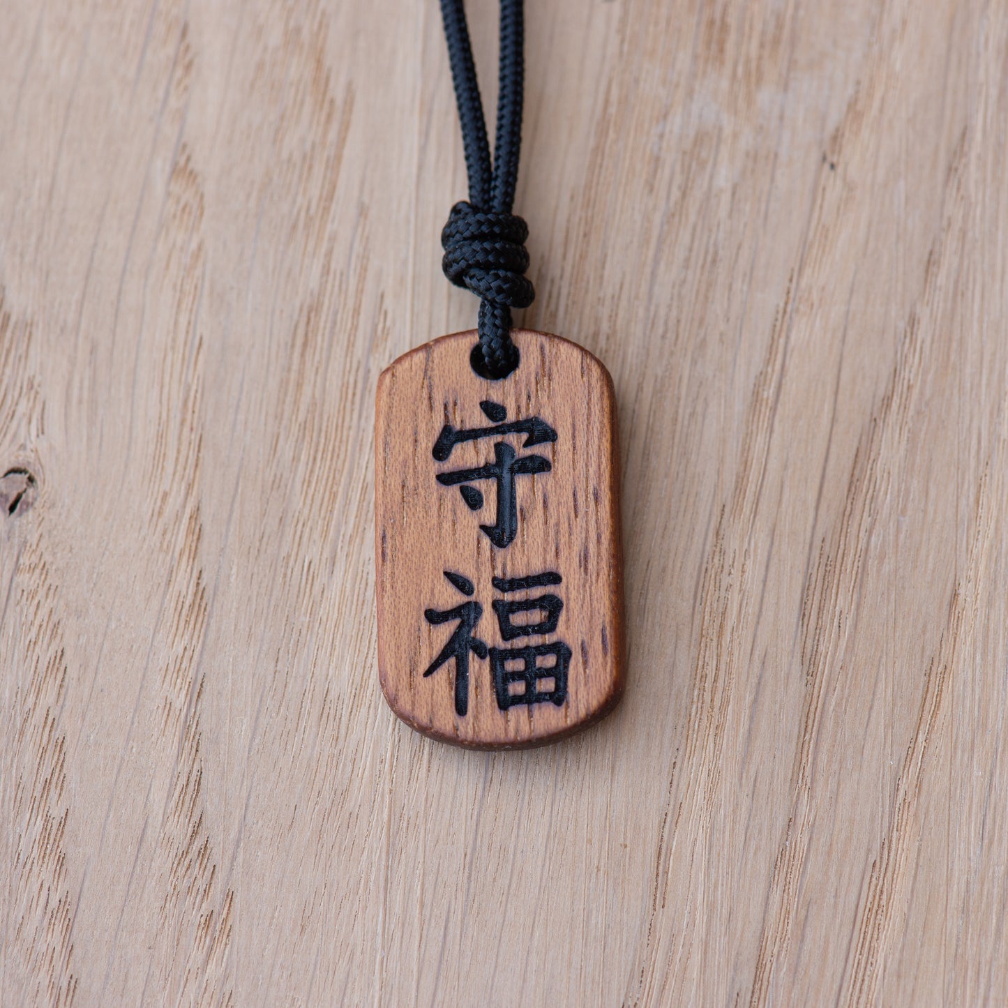 Kanji protection and fortune wooden pendant engraved with Mamoru and Fuku symbols in Iroko wood