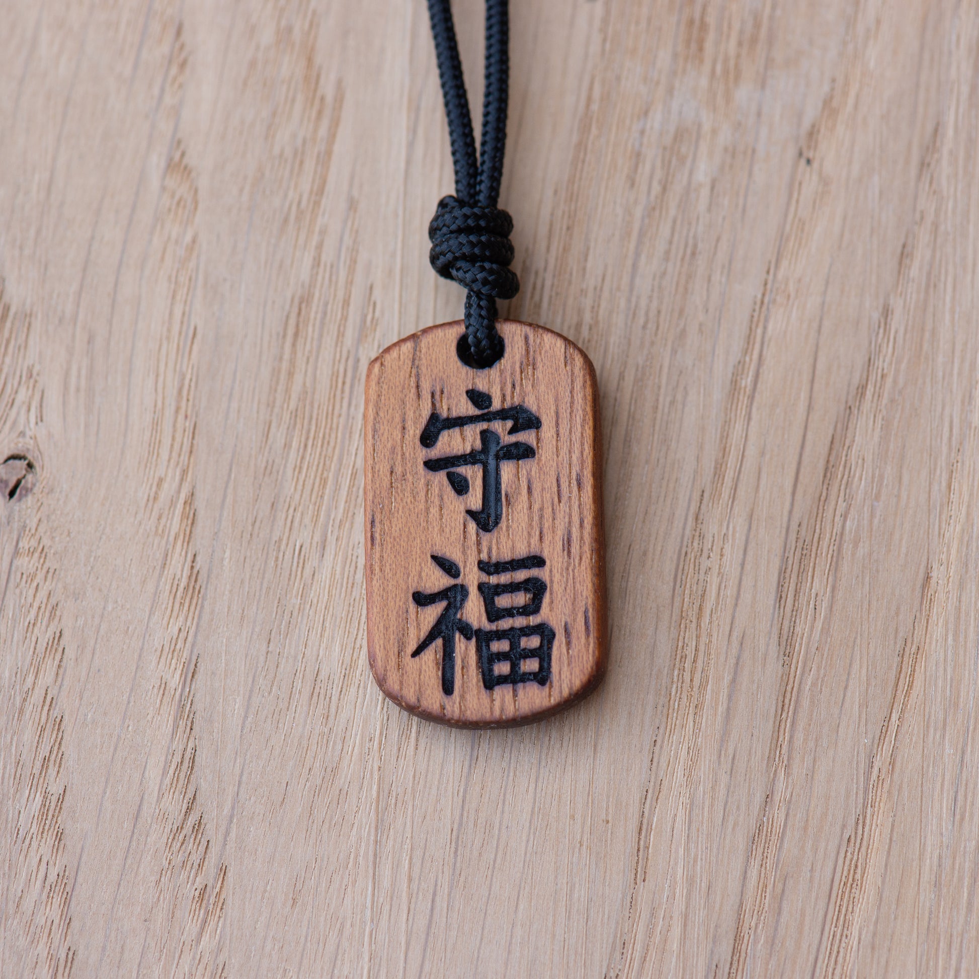 Kanji protection and fortune wooden pendant engraved with Mamoru and Fuku symbols in Iroko wood