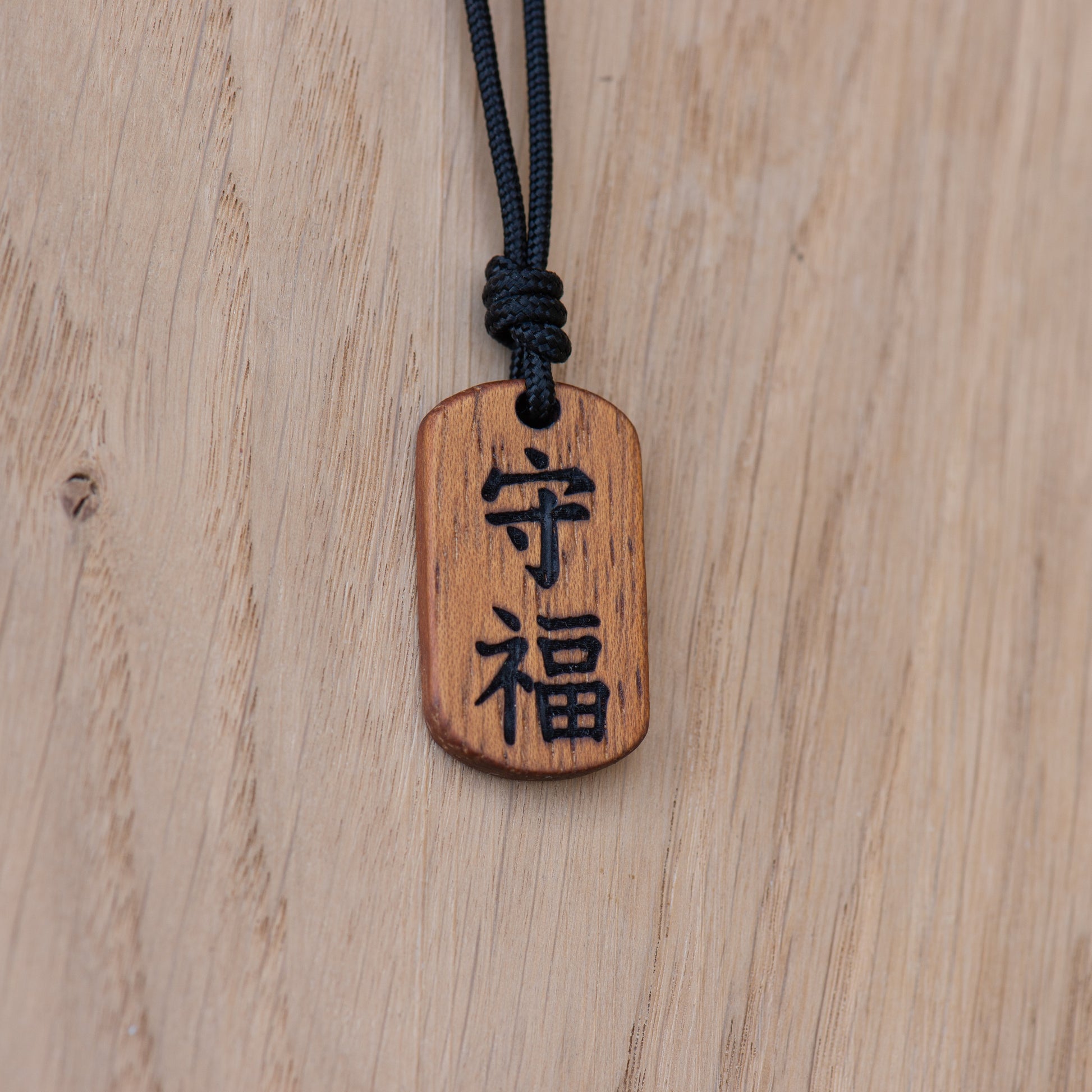 Handmade kanji wooden necklace with adjustable paracord cord in Iroko