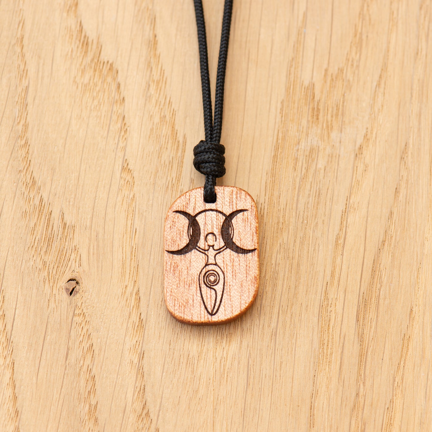 Detailed engraving of Triple Moon Goddess on handcrafted wood