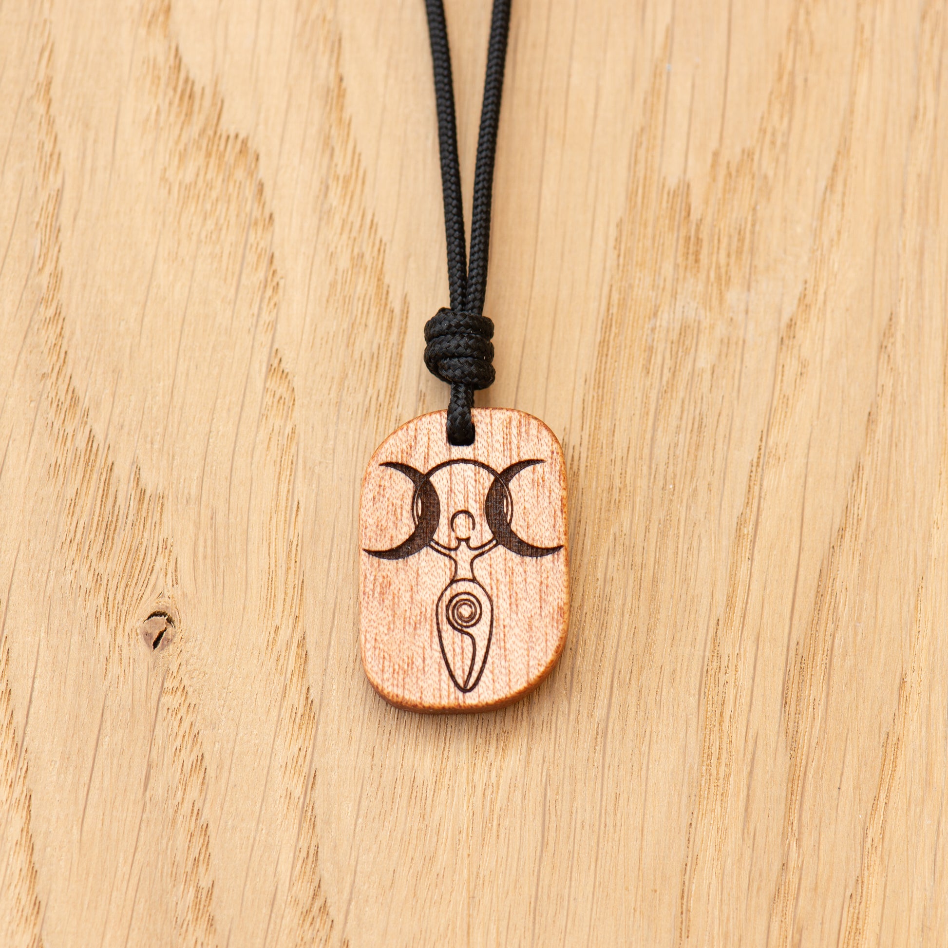 Detailed engraving of Triple Moon Goddess on handcrafted wood