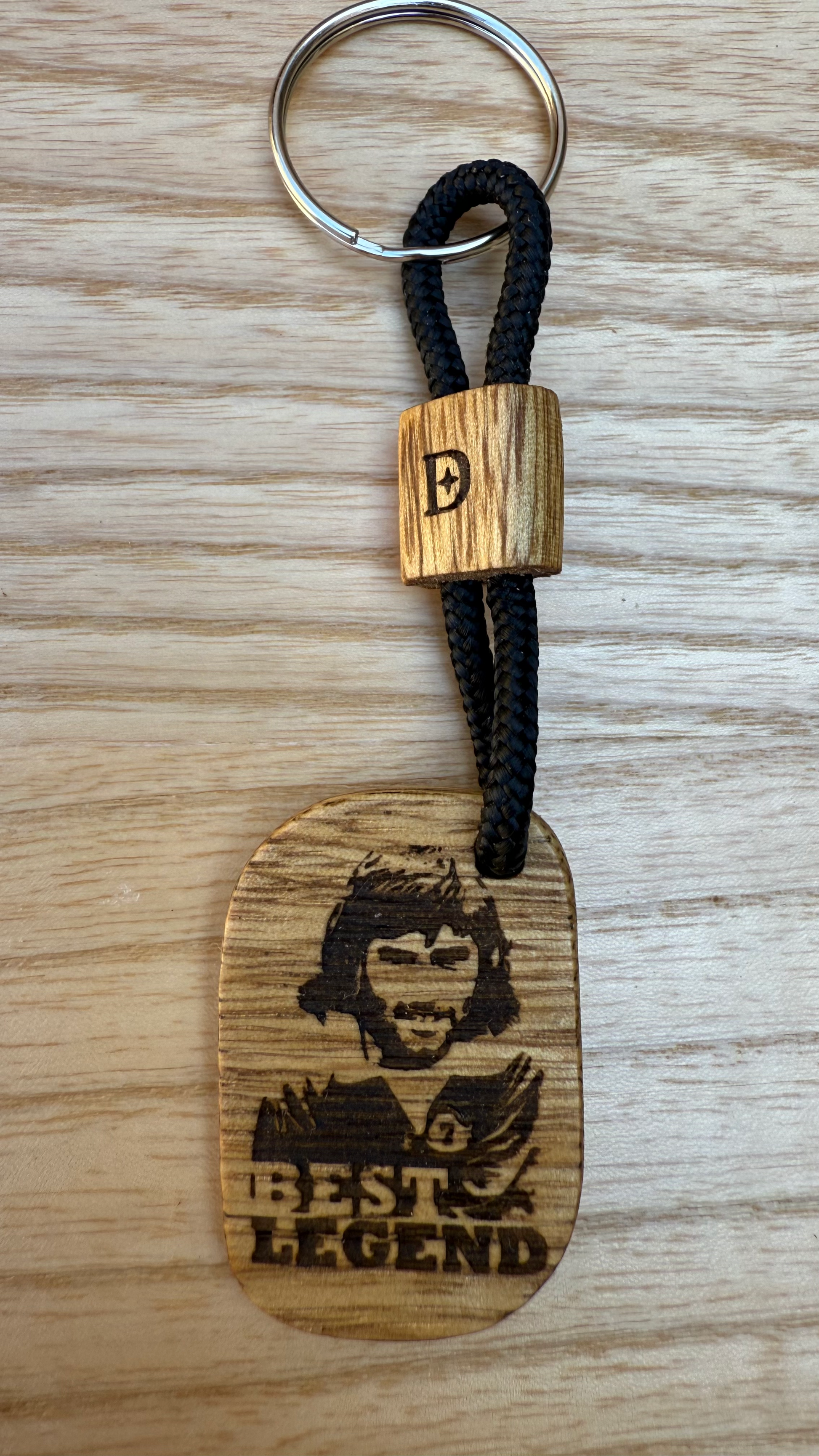 Portachiavi artigianale in legno di Korina inciso con il volto di George Best – Dogstar Lab
